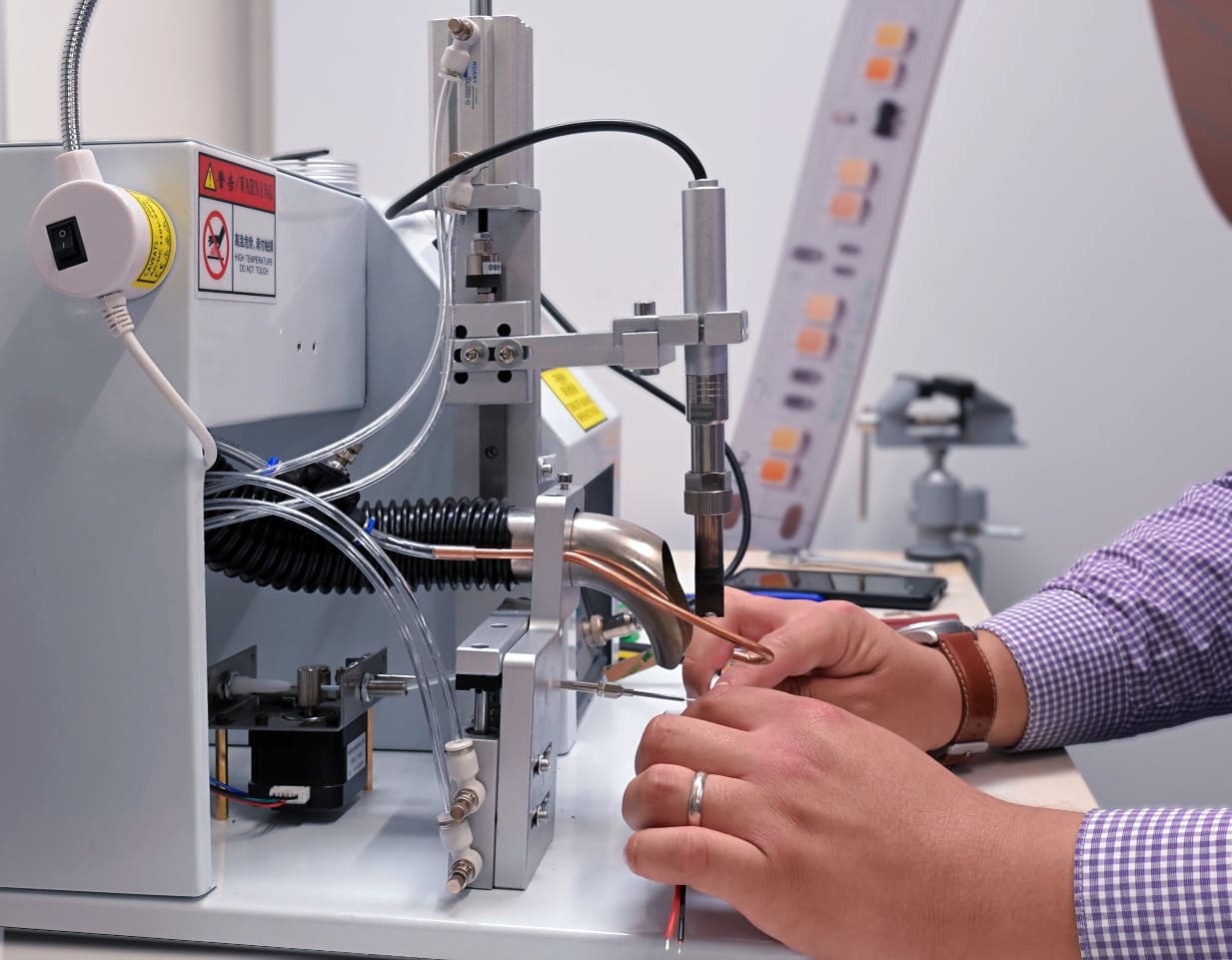 Technician using a specialized labeling machine for wire assembly.